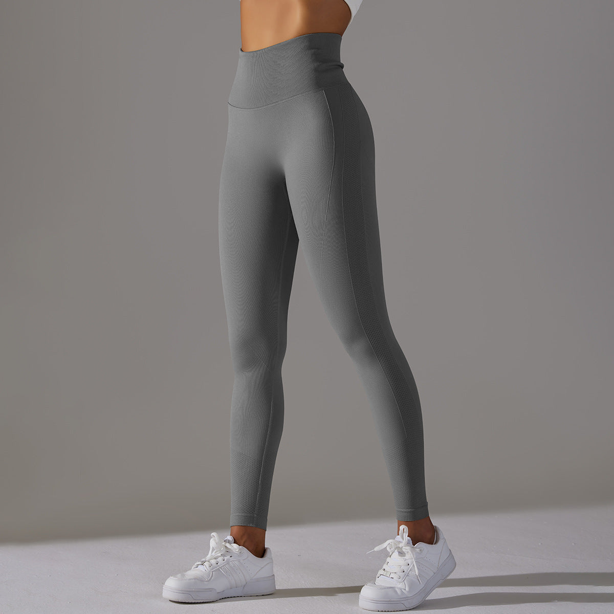 Front view of dark gray seamless high-waist leggings for workout and yoga, model wearing white sneakers