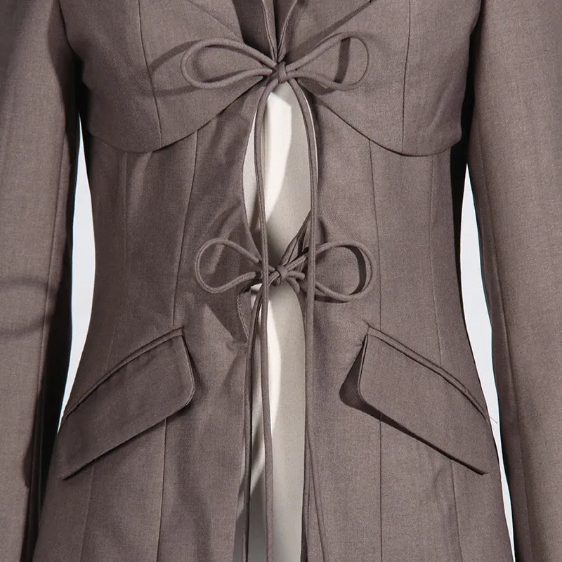 Close up of lace up front detail of a luxury fashion inspired brown hollow-out cinched irregular long sleeve blazer on a mannequin