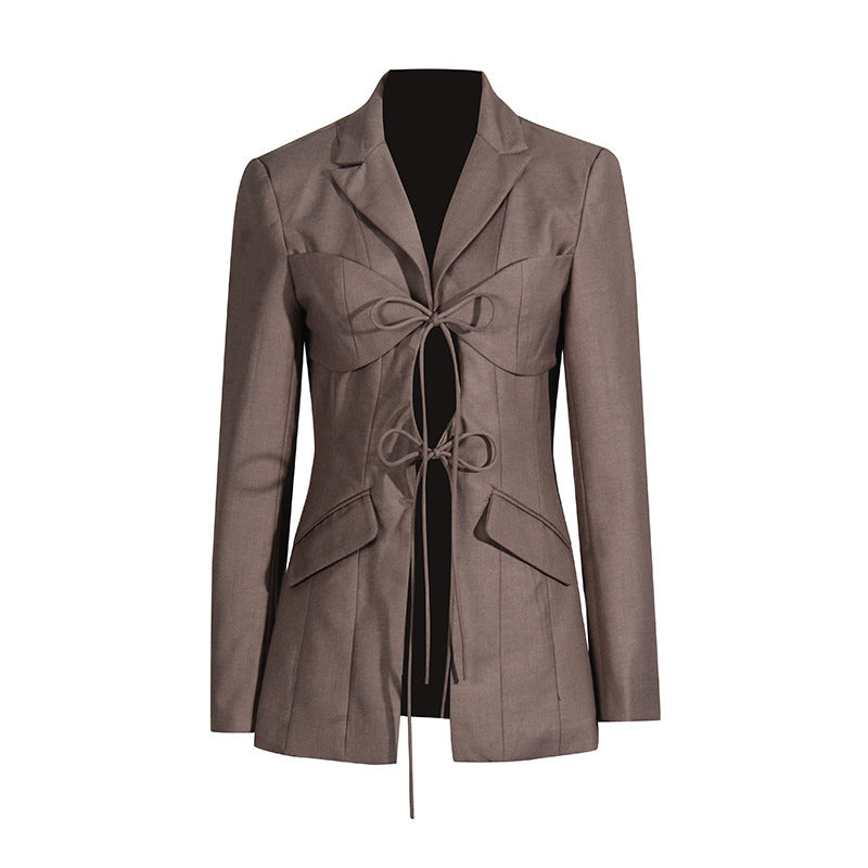 A luxury fashion inspired brown hollow-out cinched irregular  longs sleeve blazer with a deep v-neckline and lace up front detail on a white background