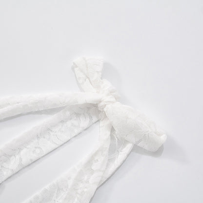 Close up of halter tie of lace maxi evening dress fabric with a textured pattern on a light background