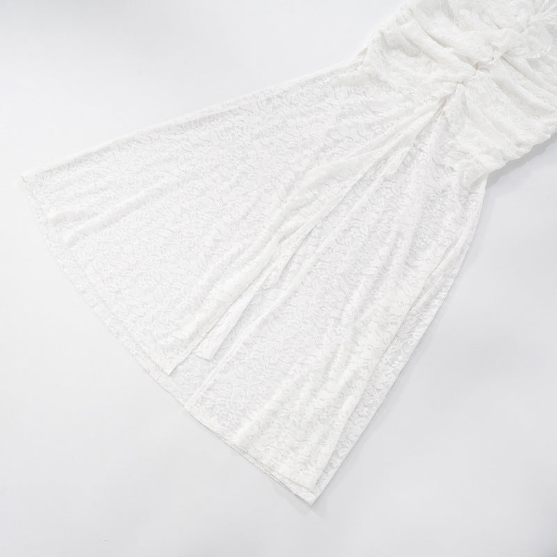 Close up of slit of white lace backless maxi dress on a light background
