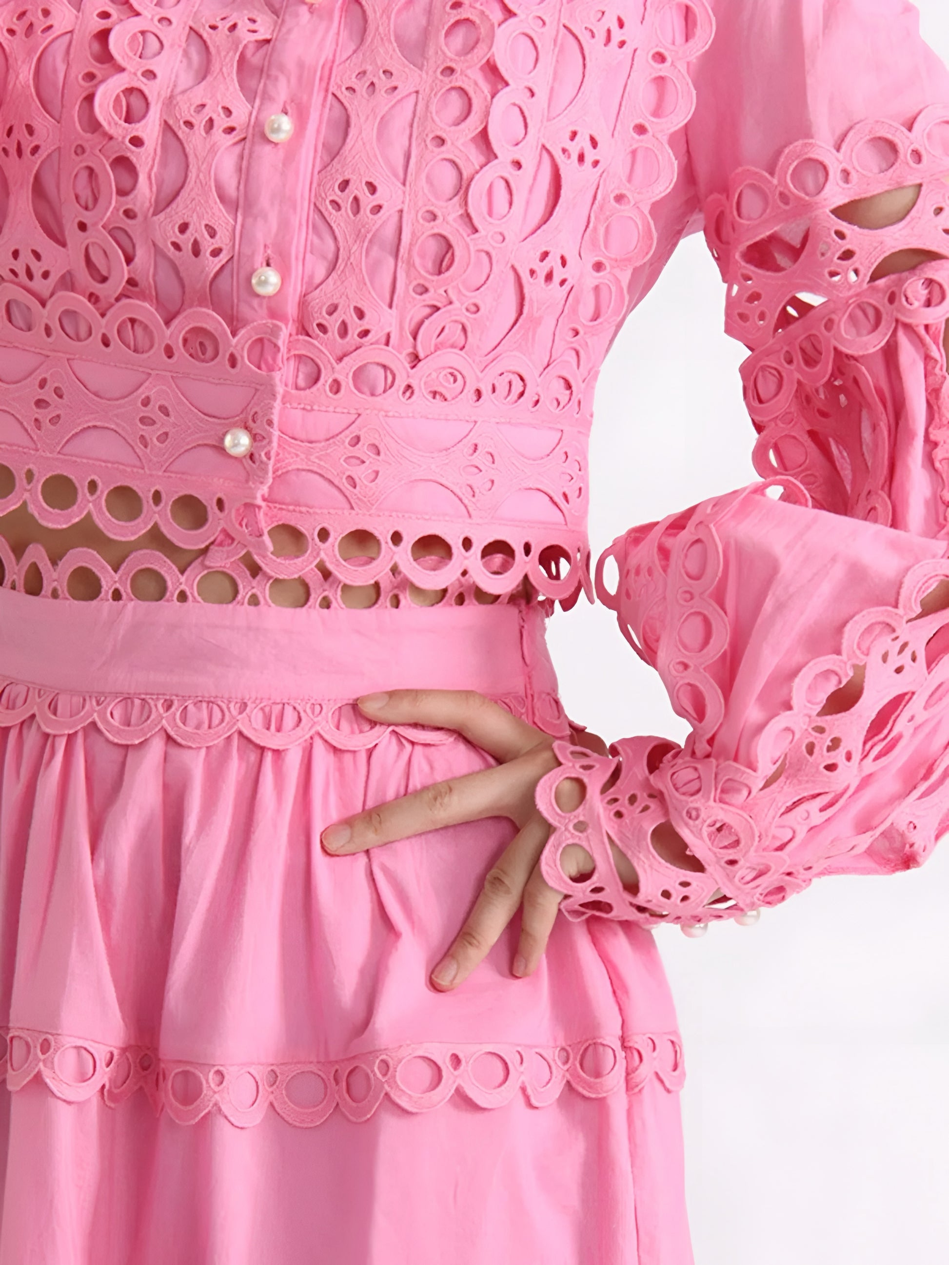 Close-up of a pink lace two piece matching set  long sleeve top  with maxi tiered skirt on a white background