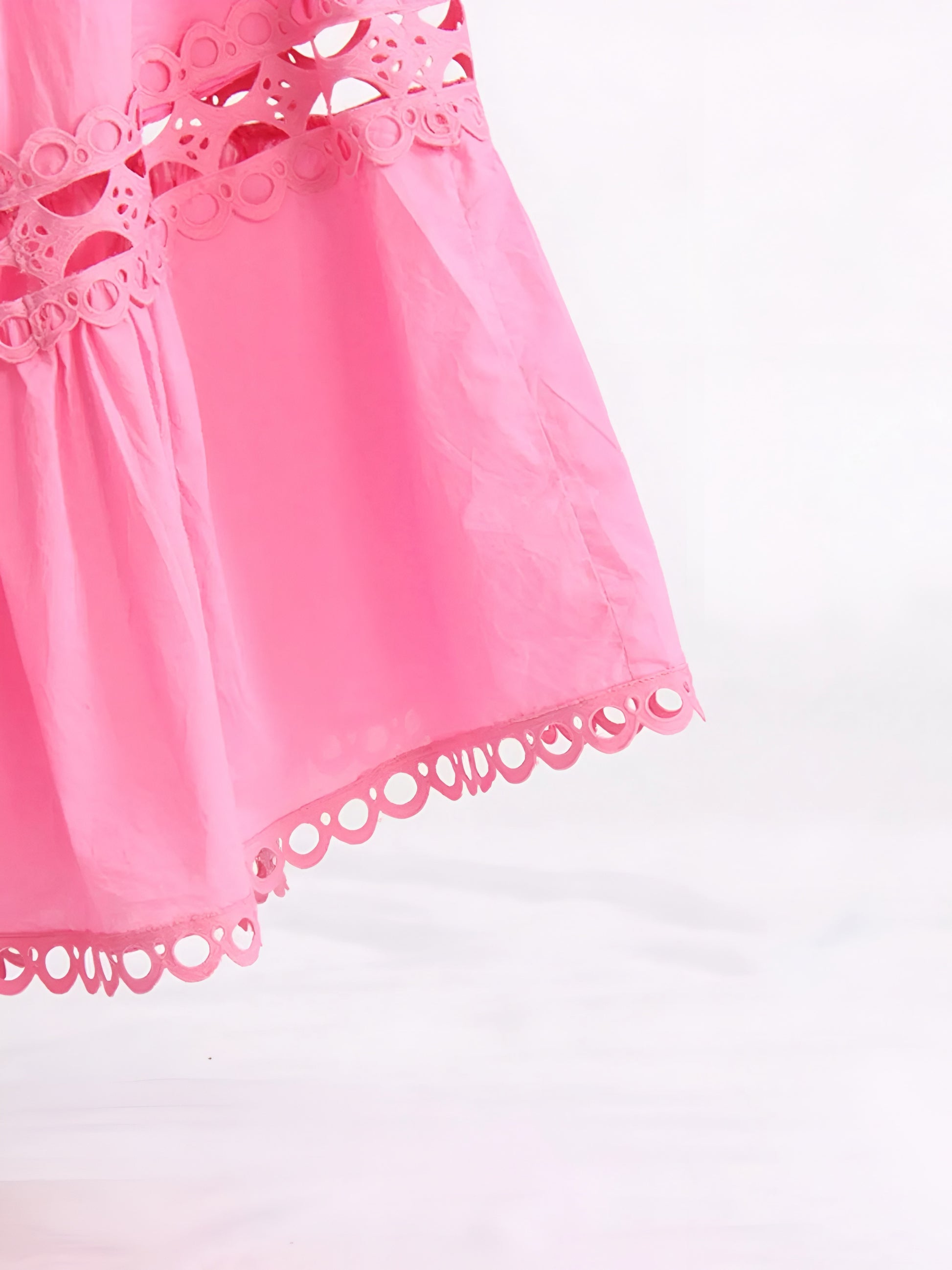 Close-up of a pink tiered maxi lace cutout skirt on a white background