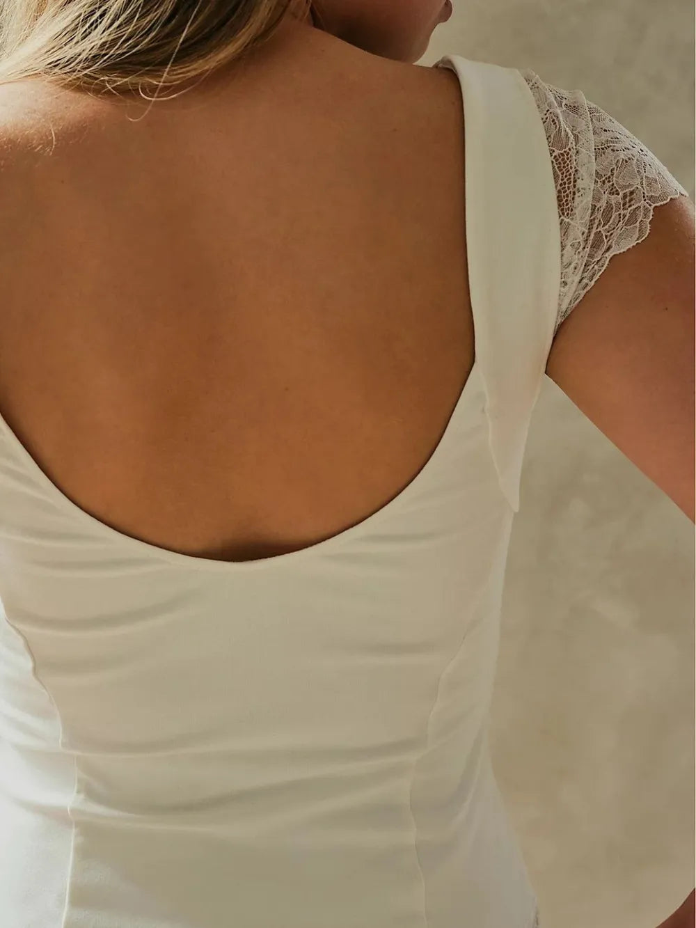 Close up of Lace Detail V-Neck Cap Sleeve Top back view on a neutral background