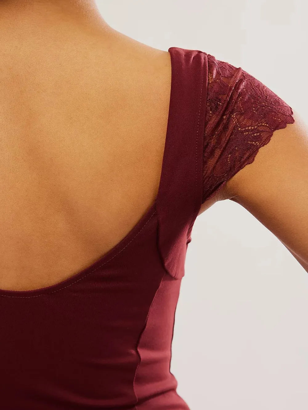 Close-up of a burgundy/maroon Lace Detail V-Neck Cap Sleeve Top back view on a plain background