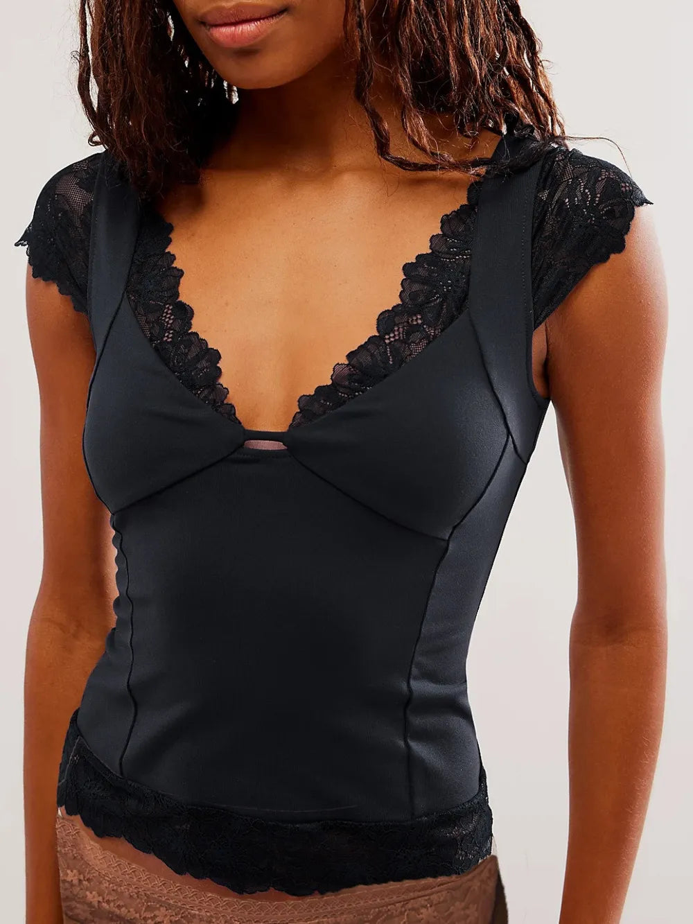 Woman wearing a Black Lace Detail V-Neck Cap Sleeve Top on a plain background