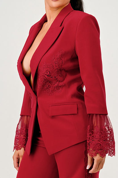 Woman wearing a high fashion luxury burgundy/red lace blazer