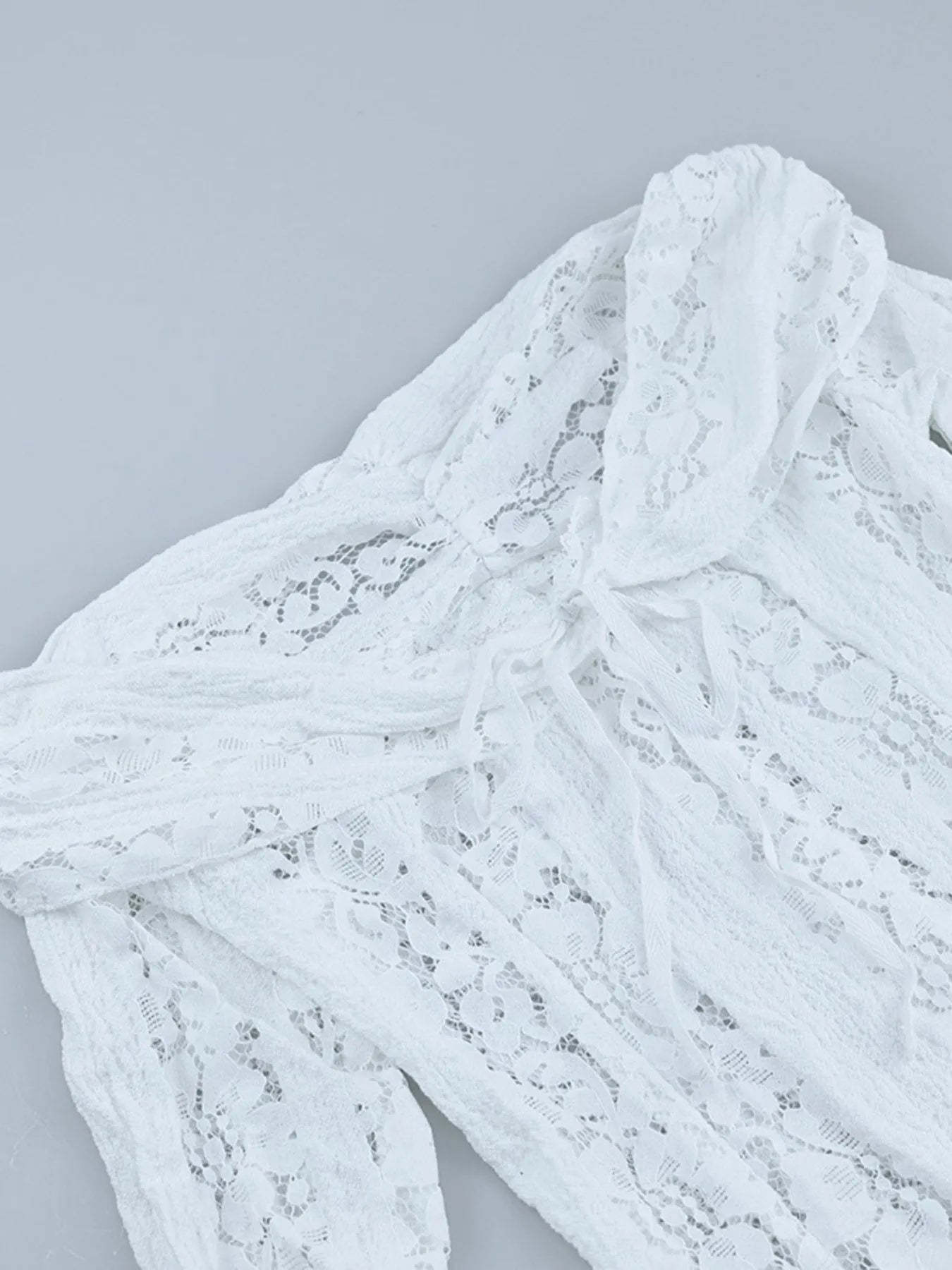 Close-up of a neckline of white Lace Off-Shoulder Maxi Dress with Flounce Sleeves on a light gray background
