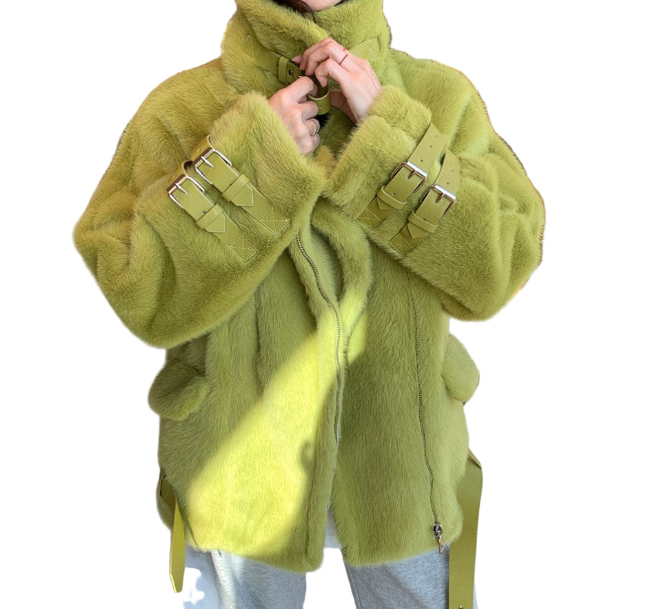 A woman wearing a fashionable streetwear chic green faux fur coat with a stand-up collar and leather buckles