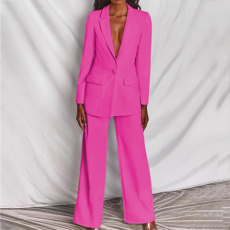 Woman modeling a bright pink elegant long sleeve blazer and matching trousers suit set.

