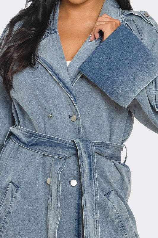 Close-up of vintage light wash denim trench coat with belted waist and front button closure
