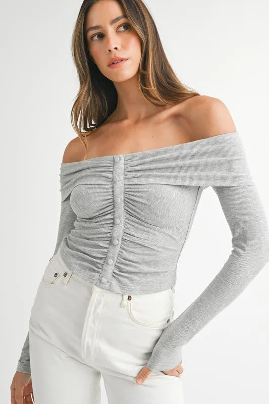 Model in off-shoulder long sleeve gray knit top with relaxed silhouette