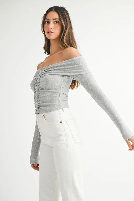 Model in off-shoulder long sleeve knit top with relaxed silhouette side view