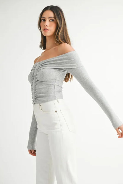 Model in off-shoulder long sleeve knit top with relaxed silhouette side view