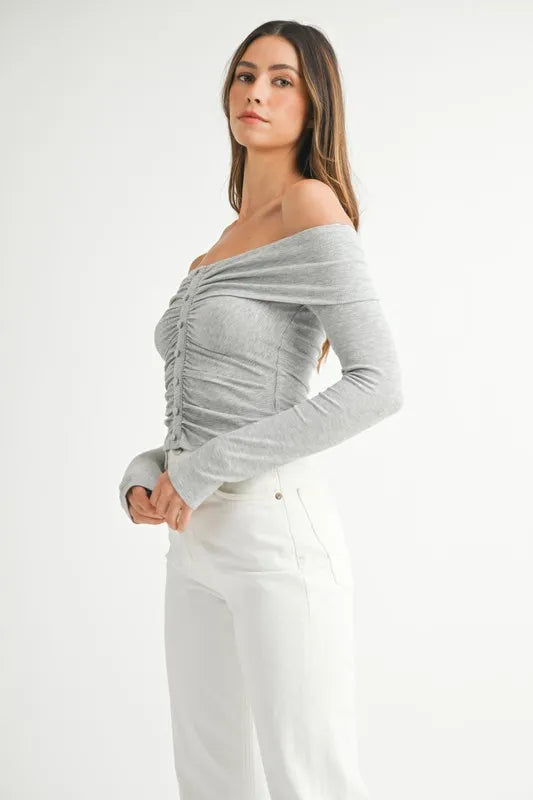 Model in off-shoulder long sleeve  gray knit top with relaxed silhouette side view