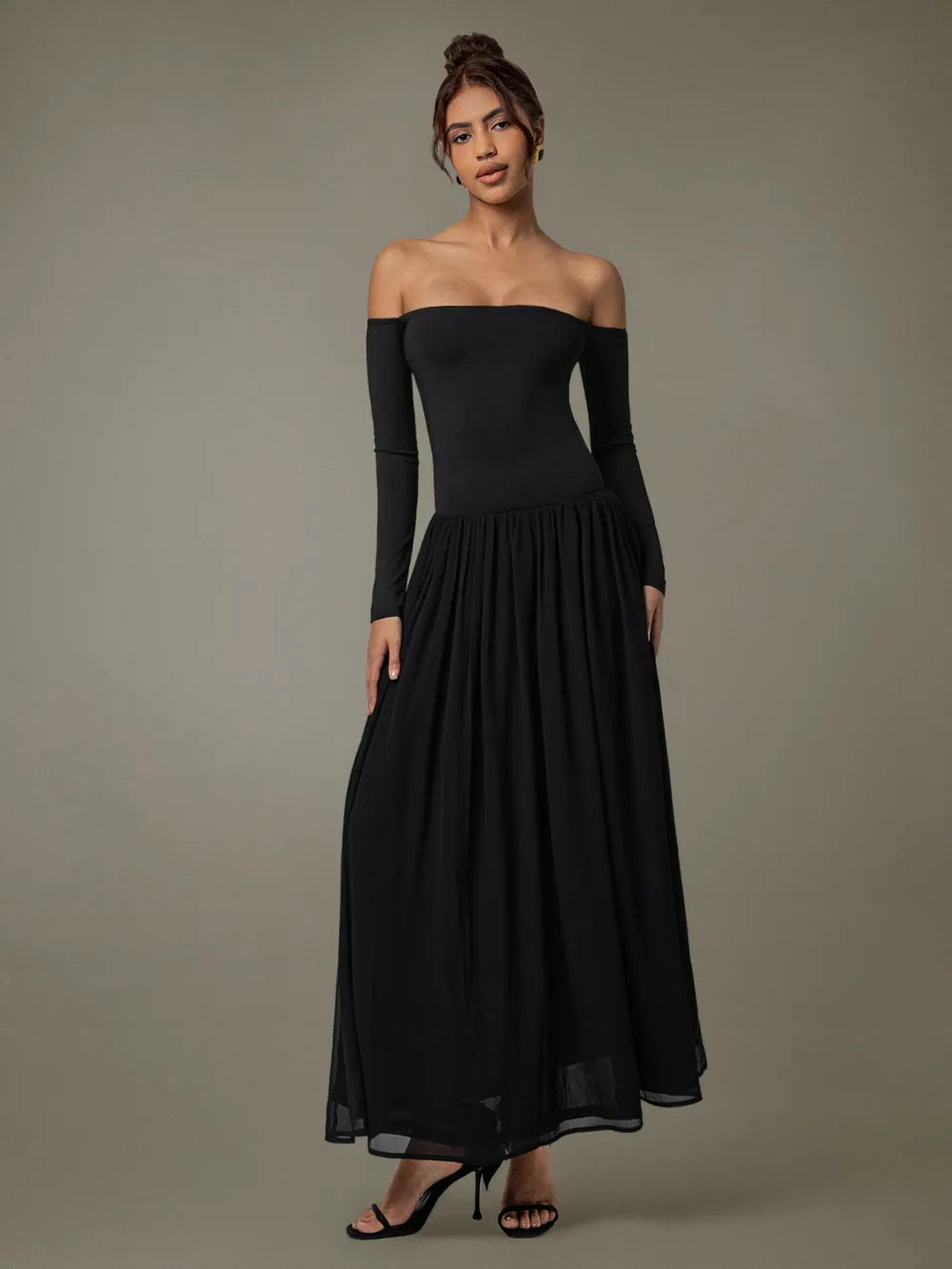 Model wearing off-shoulder long sleeve maxi dress front view in soft neutral tone background 