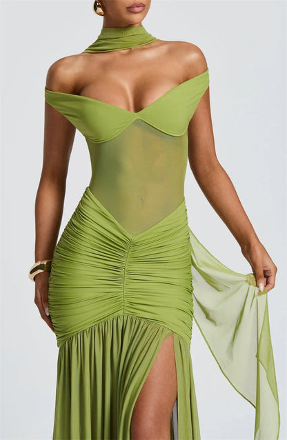 Woman in a green off shoulder backless split maxi dress front view close up