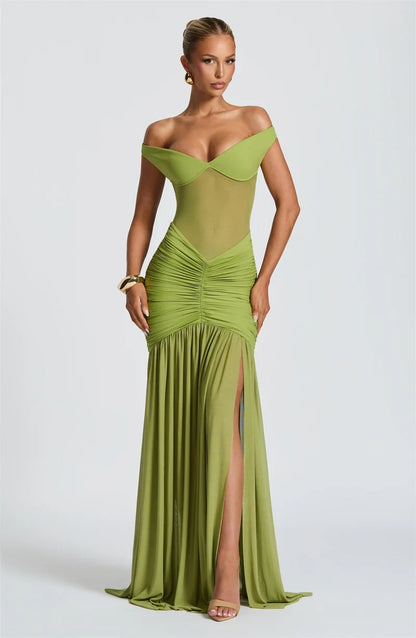Woman in a green off shoulder backless split evening dress front view
