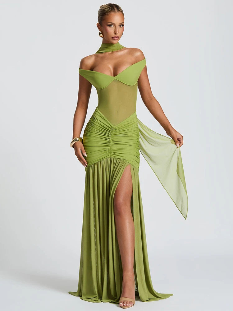 Woman in a green off shoulder backless high thigh slit maxi dress with flowy hem 