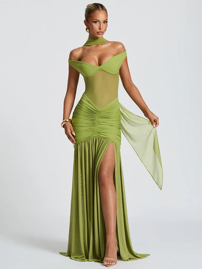 Woman in a green off shoulder backless high thigh slit maxi dress with flowy hem 