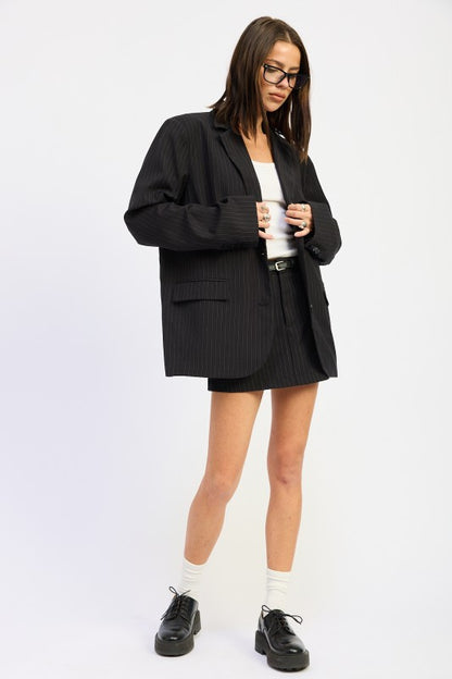 Women’s Fashion Oversized Black Button front Blazer with Stripes and flap pockets on a model on a white background