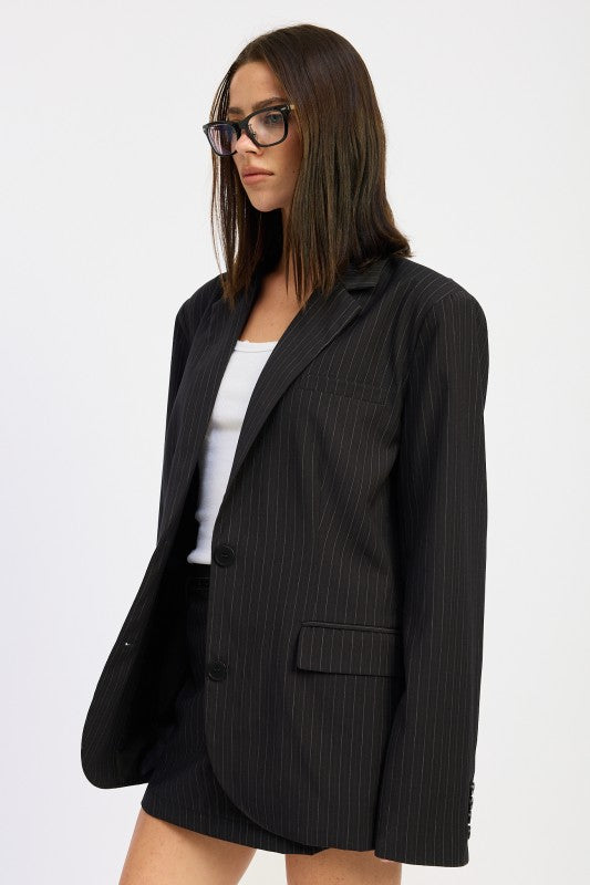 side view of a woman wearing a black trendy pinstripe oversized blazer outfit