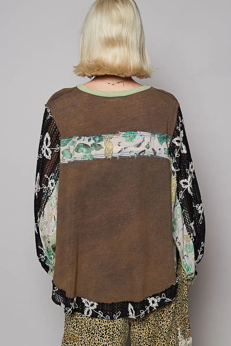 Model wearing floral patchwork blouse with crochet lace long sleeves back of blouse showing relaxed fit and floral pattern