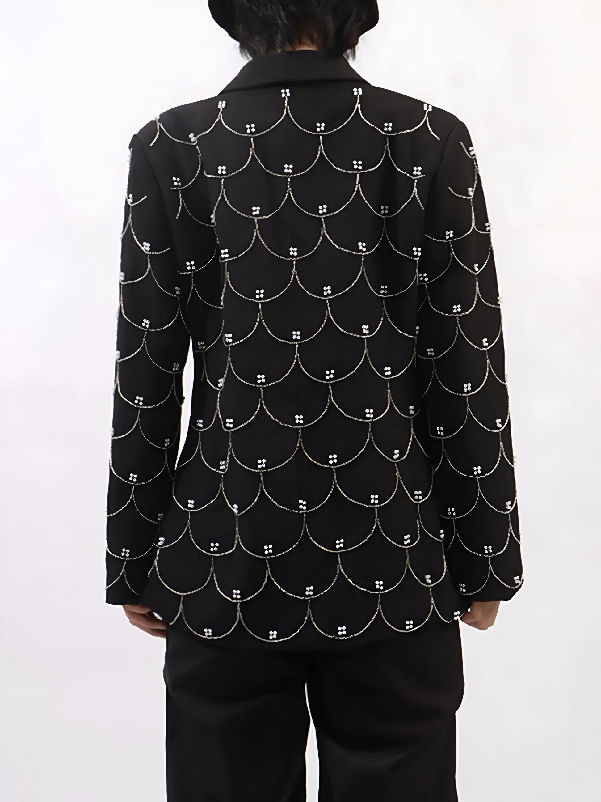 back view of woman wearing a black couture designer inspired pearl-embellished statement blazer