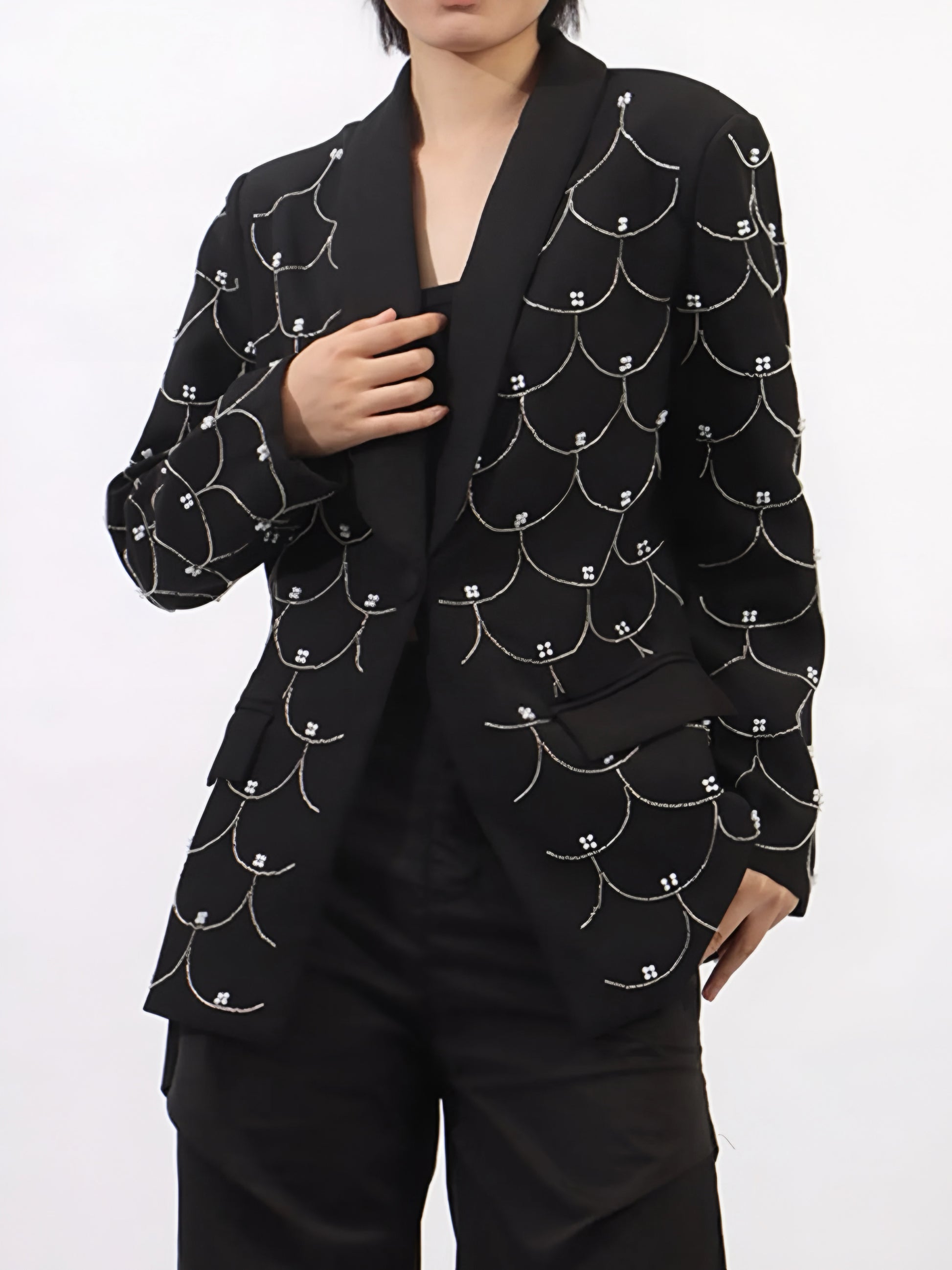 front view of woman wearing a black couture designer inspired pearl-embellished statement blazer