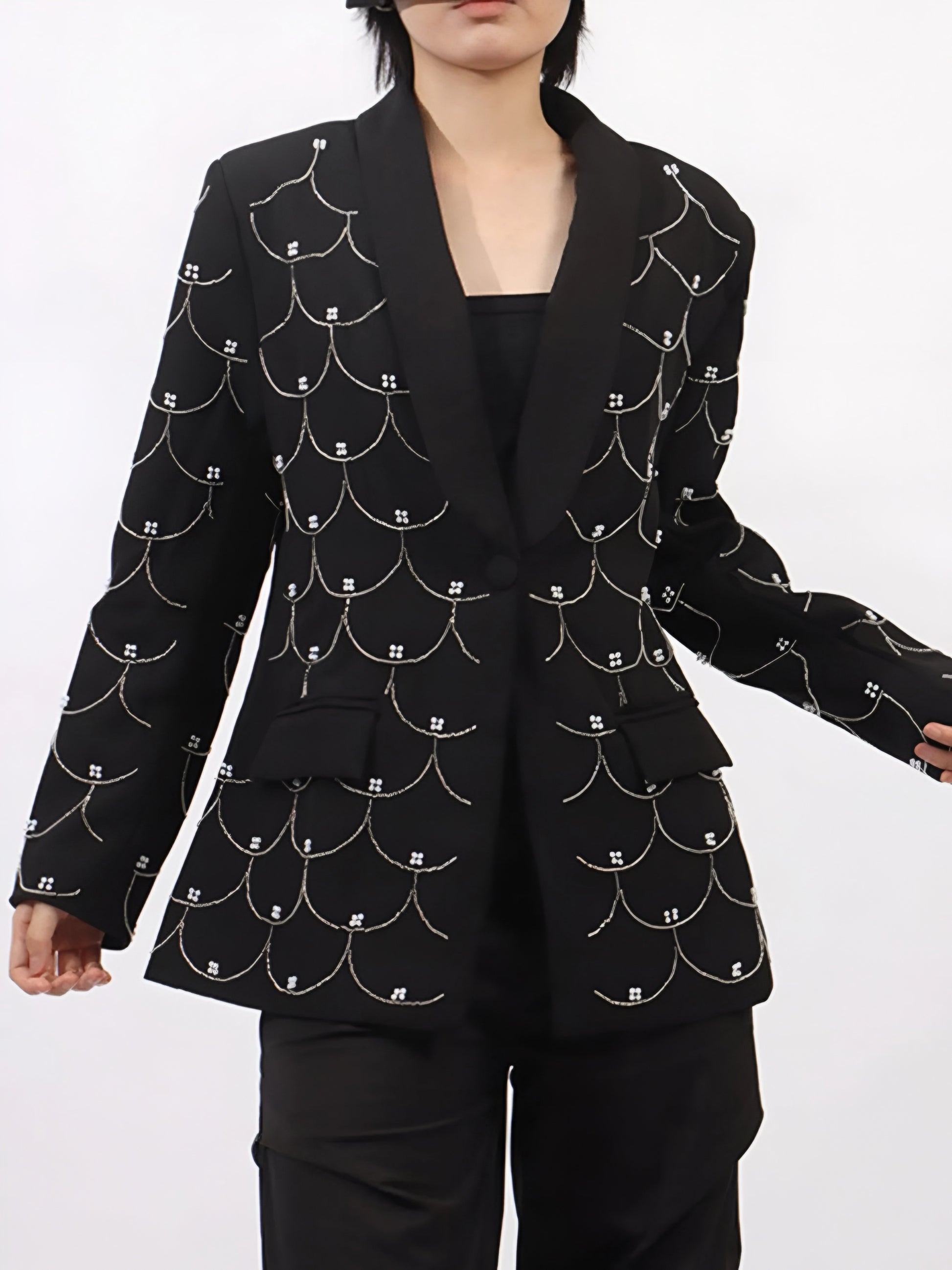 Woman wearing a black women’s tailored blazer with pearl embellishments  with front button