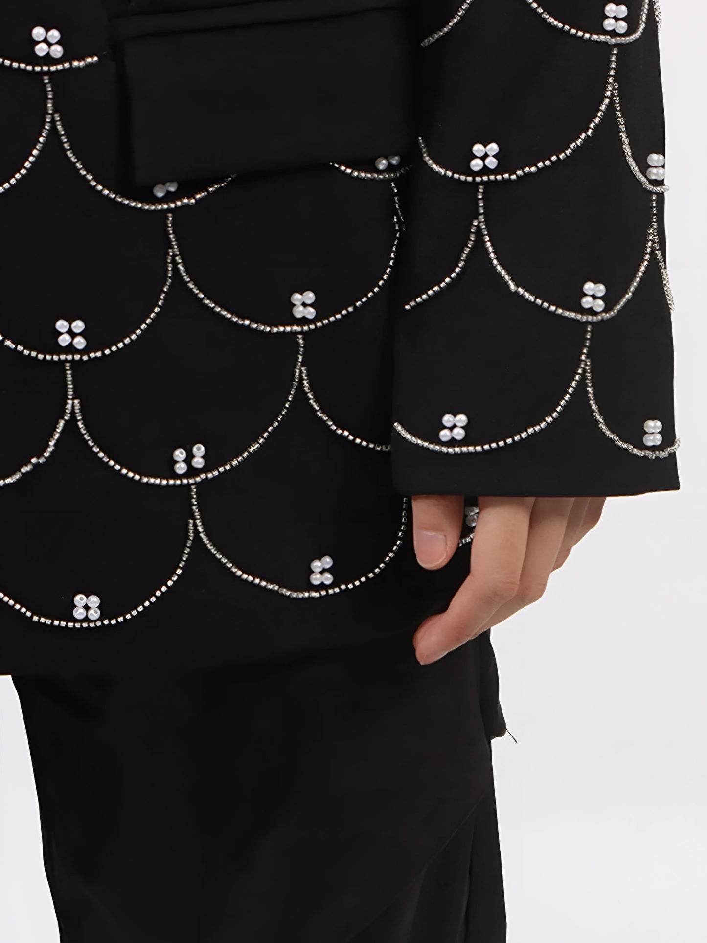 Close up of women’s tailored blazer with all over pearl embellishments