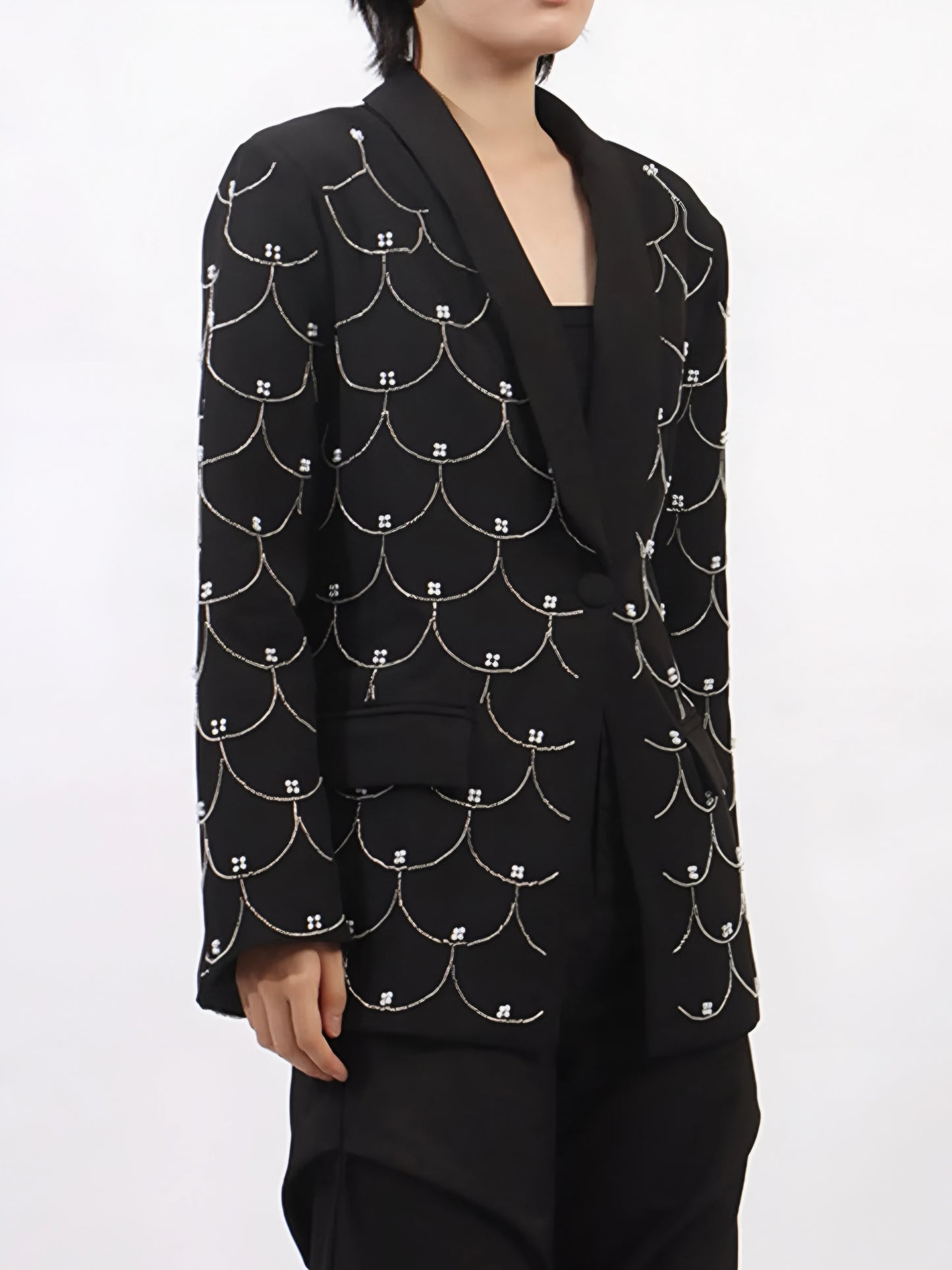 side view of woman wearing a black couture designer inspired pearl-embellished statement blazer