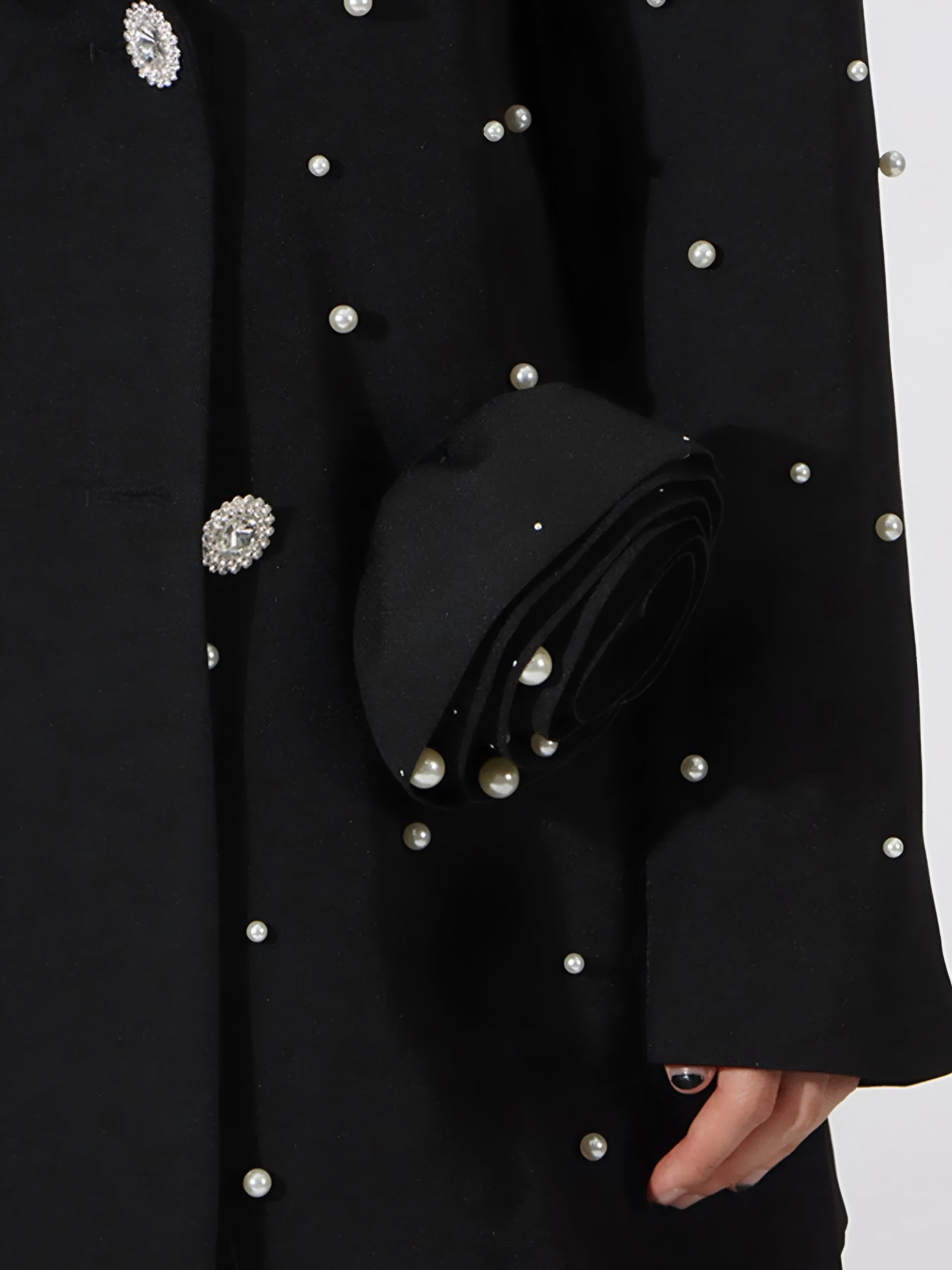 Black high fashion statement blazer with pearl embellishments on a white background