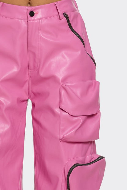 Close-up of pink leather cargo pants for women streetwear with zippers and oversized pockets on a white background