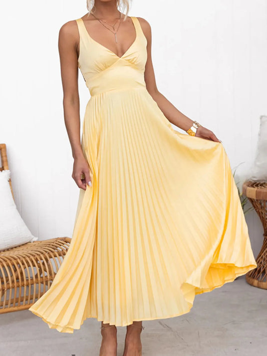 Woman wearing a yellow Flowy pleated skirt maxi dress  in an indoor setting