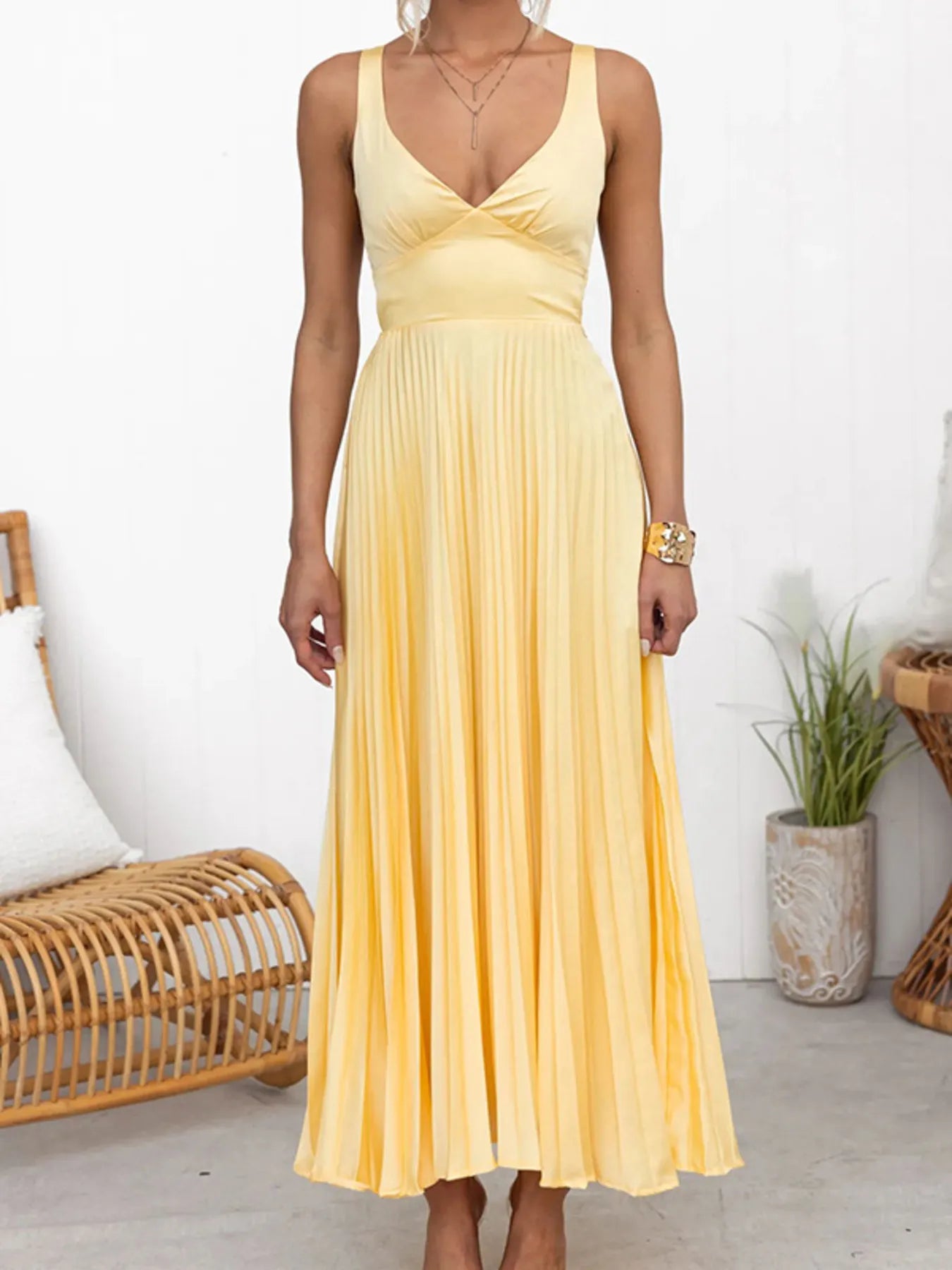 Woman wearing a yellow Elegant V‑neck pleated formal maxi dress  in a minimal indoor setting