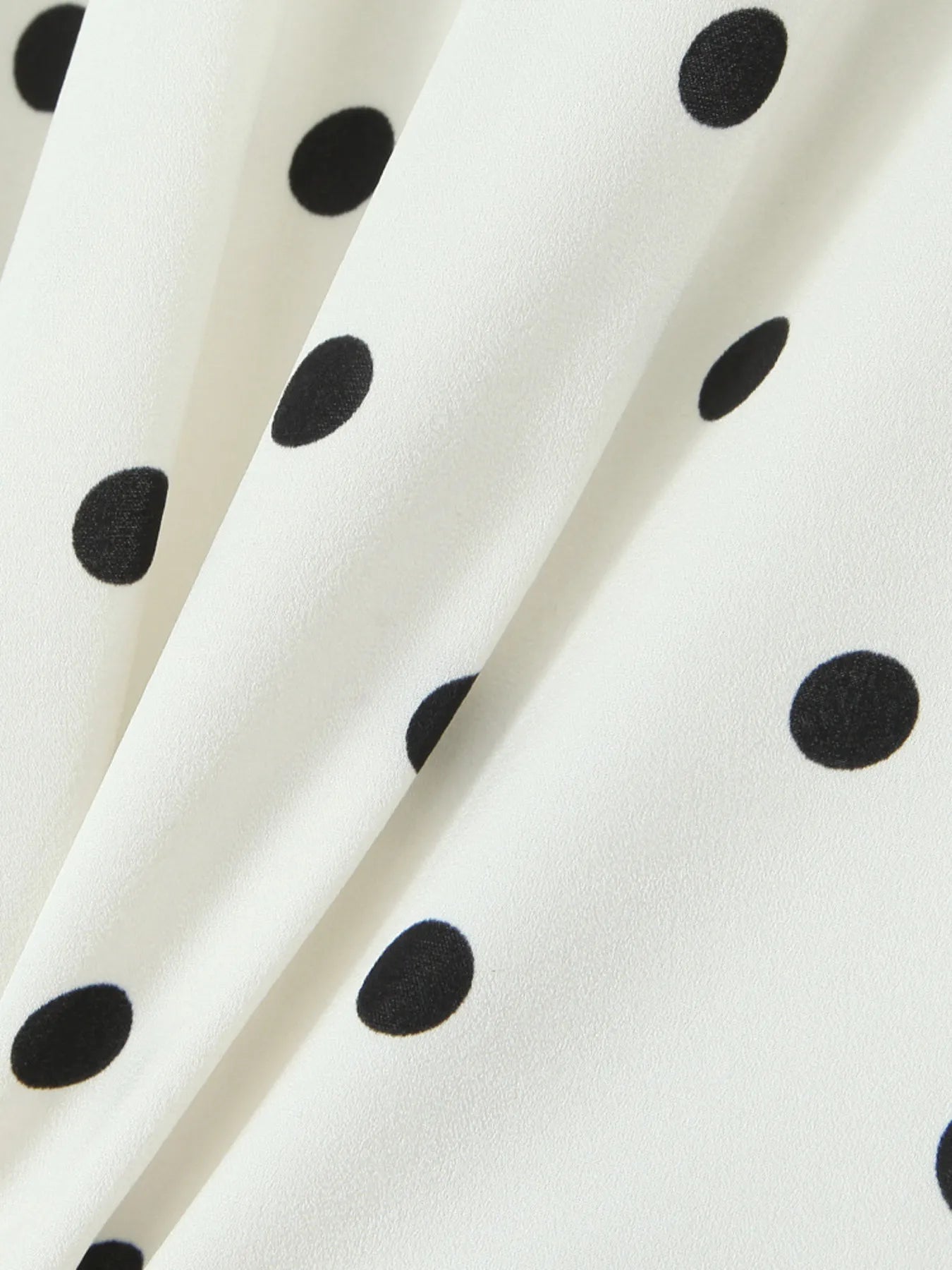 Close-up of polka dot fabric of halter neck mini dress
