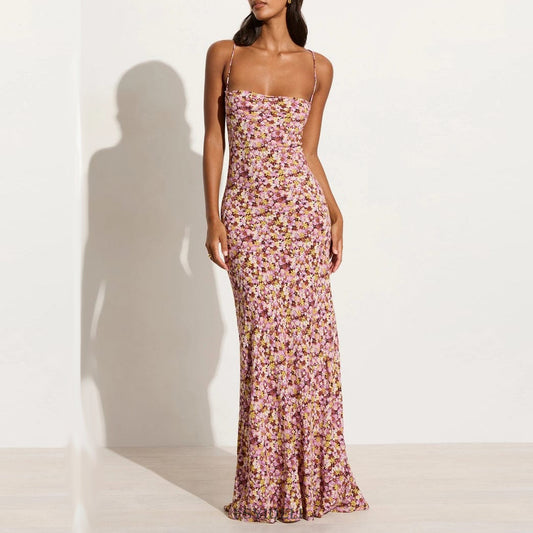 Model wearing a printed purple floral dress with a backless and lace-up feature front view