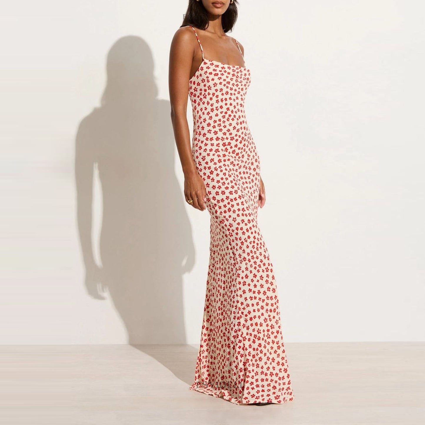 Model wearing a printed red floral dress with a backless and lace-up feature front view