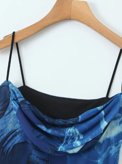 Blue floral printed mini cami dress with black straps on a wooden hanger against a white background