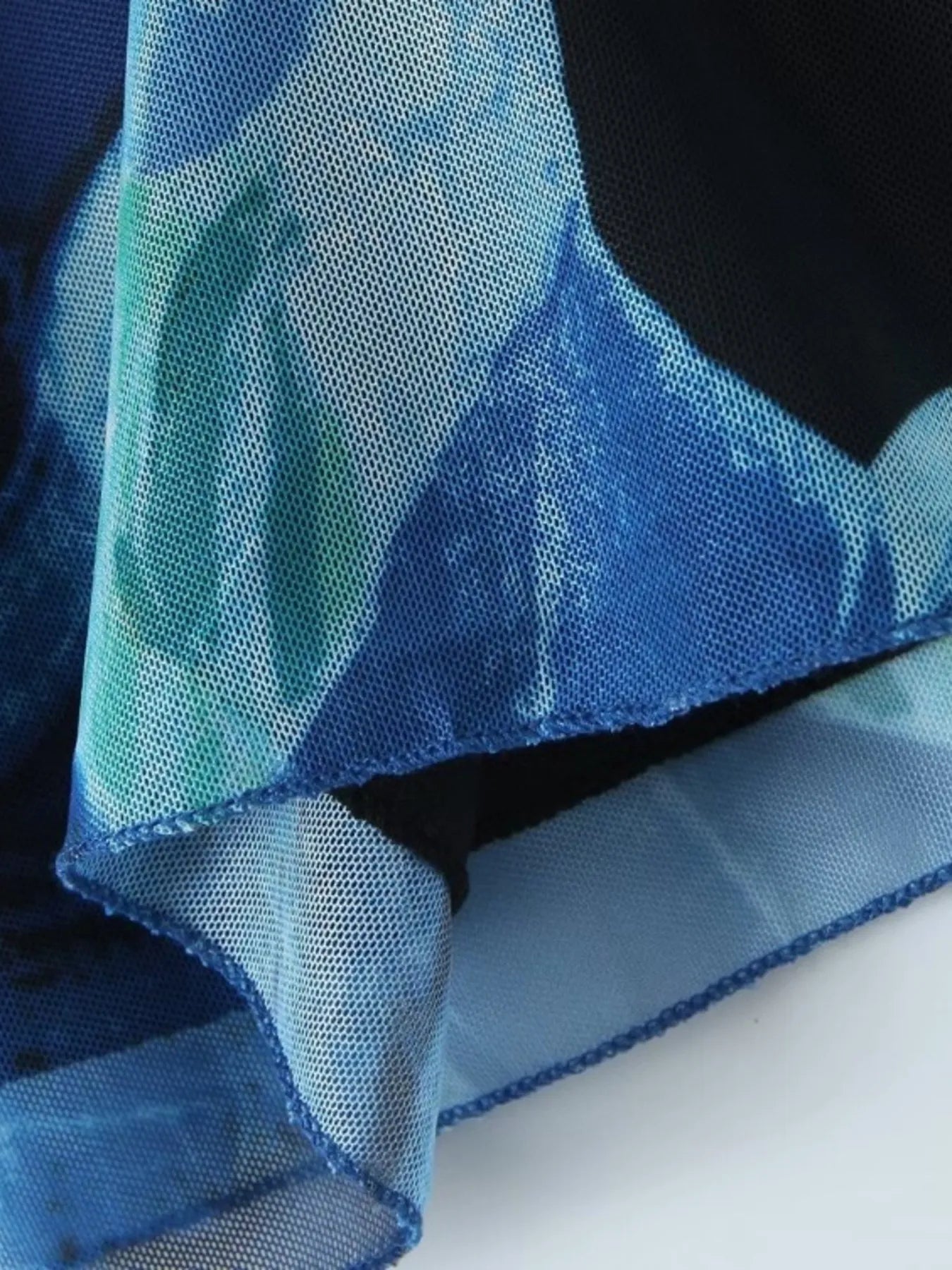 Close-up of blue mini cami dress with a floral pattern on a white background
