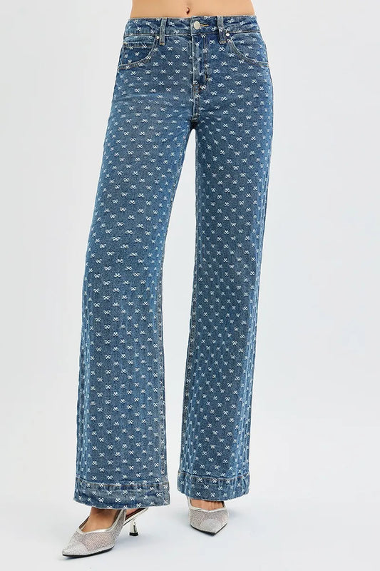 High waisted wide leg blue jeans with bow all over pattern fashion denim on woman on a white background