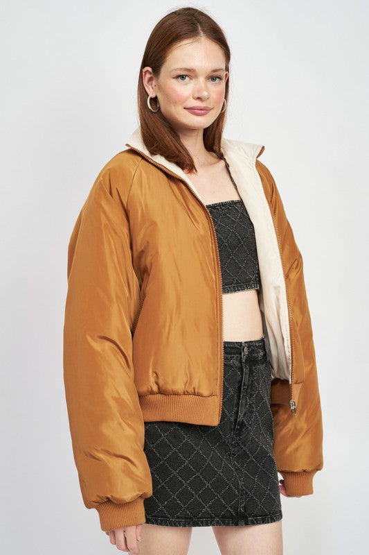 side profile view of woman in a brown/ivory front zip puffer jacket