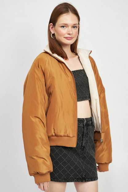 side profile view of woman in a brown/ivory front zip puffer jacket