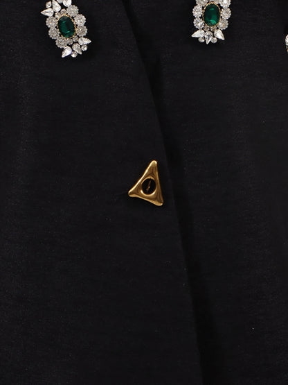 Close-up of a black statement sparkle outerwear in inclusive sizing M–3XL and green gemstone