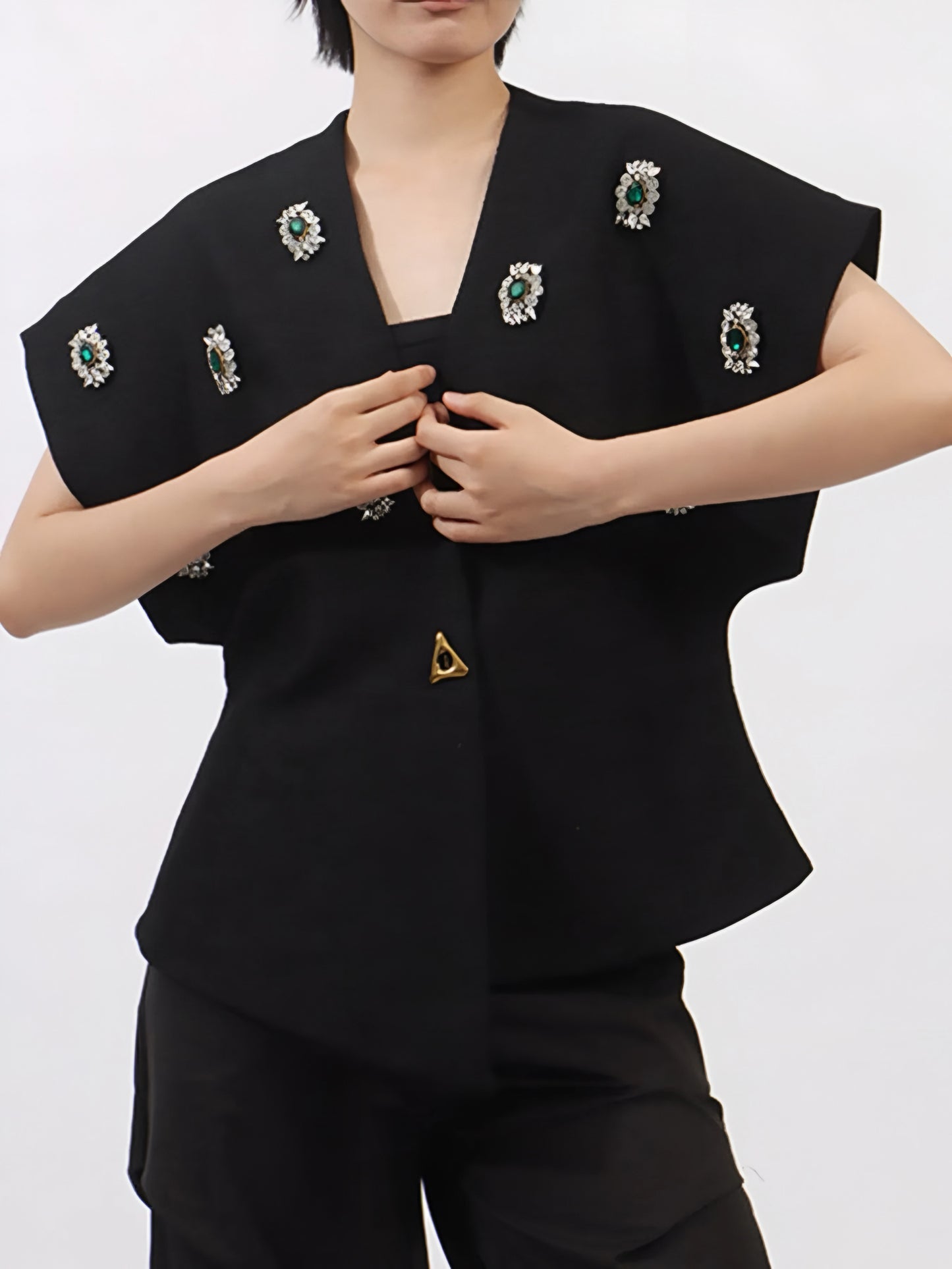 woman posing in a black statement sparkle outerwear in inclusive sizing M–3XL with decorative rhinestone gems on a plain background