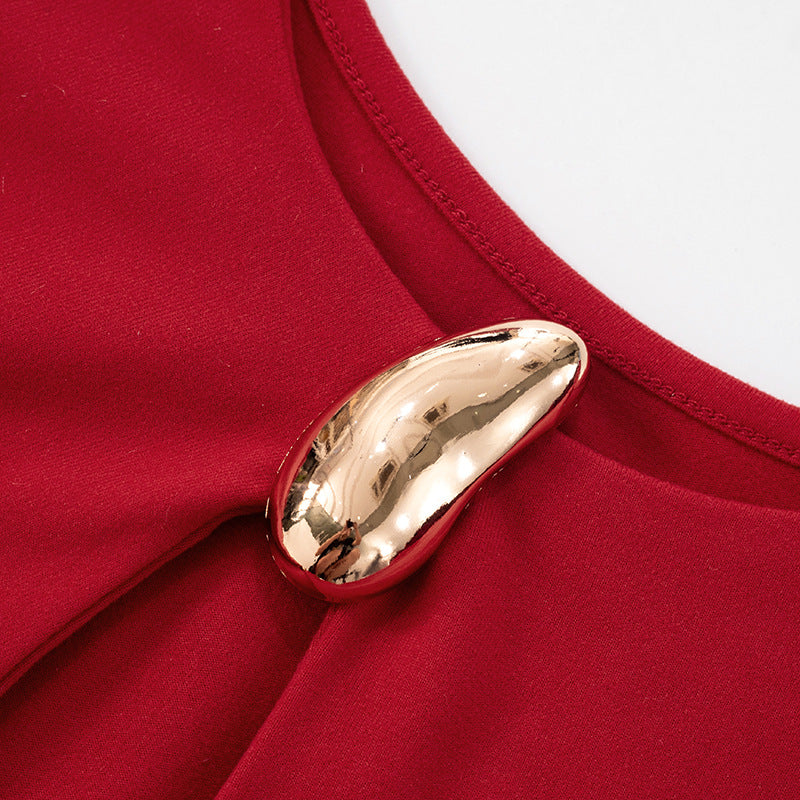 Close up of neckline for Red cutout evening gown with a gold brooch on a white background