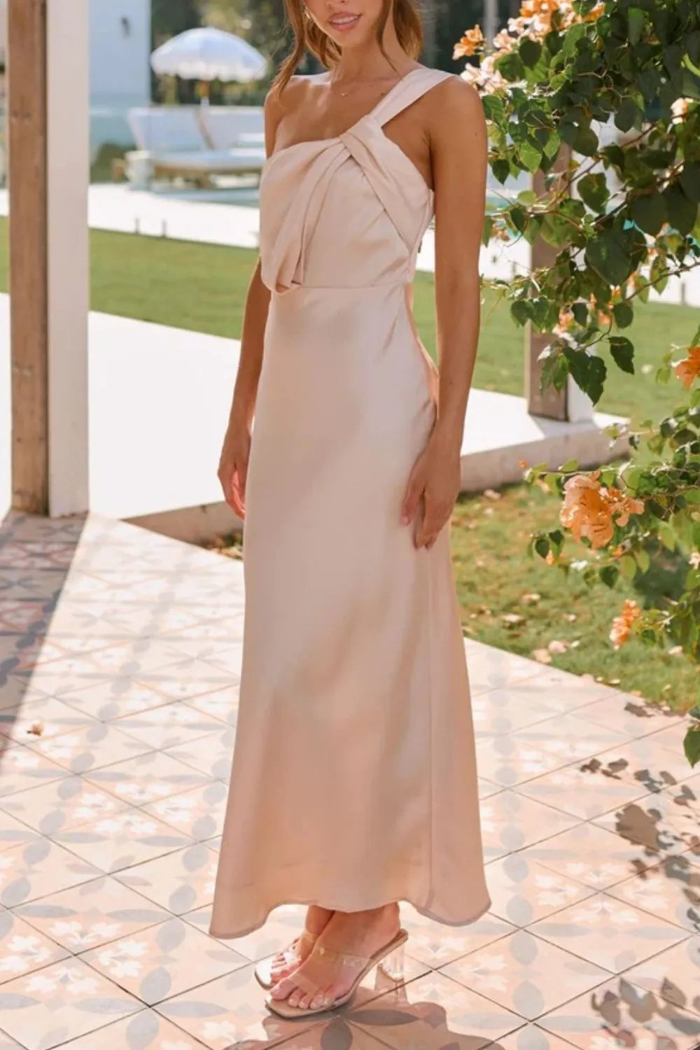 Model wearing ruched one-shoulder sleeveless maxi dress with curve-hugging fit