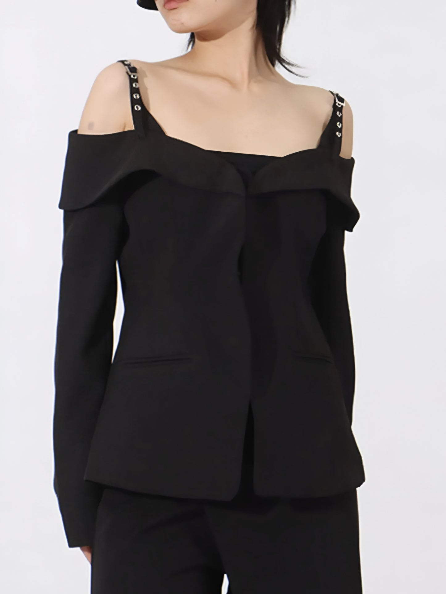 woman wearing black cold Shoulder Buckle Strap Blazer with ruffled details on a white background