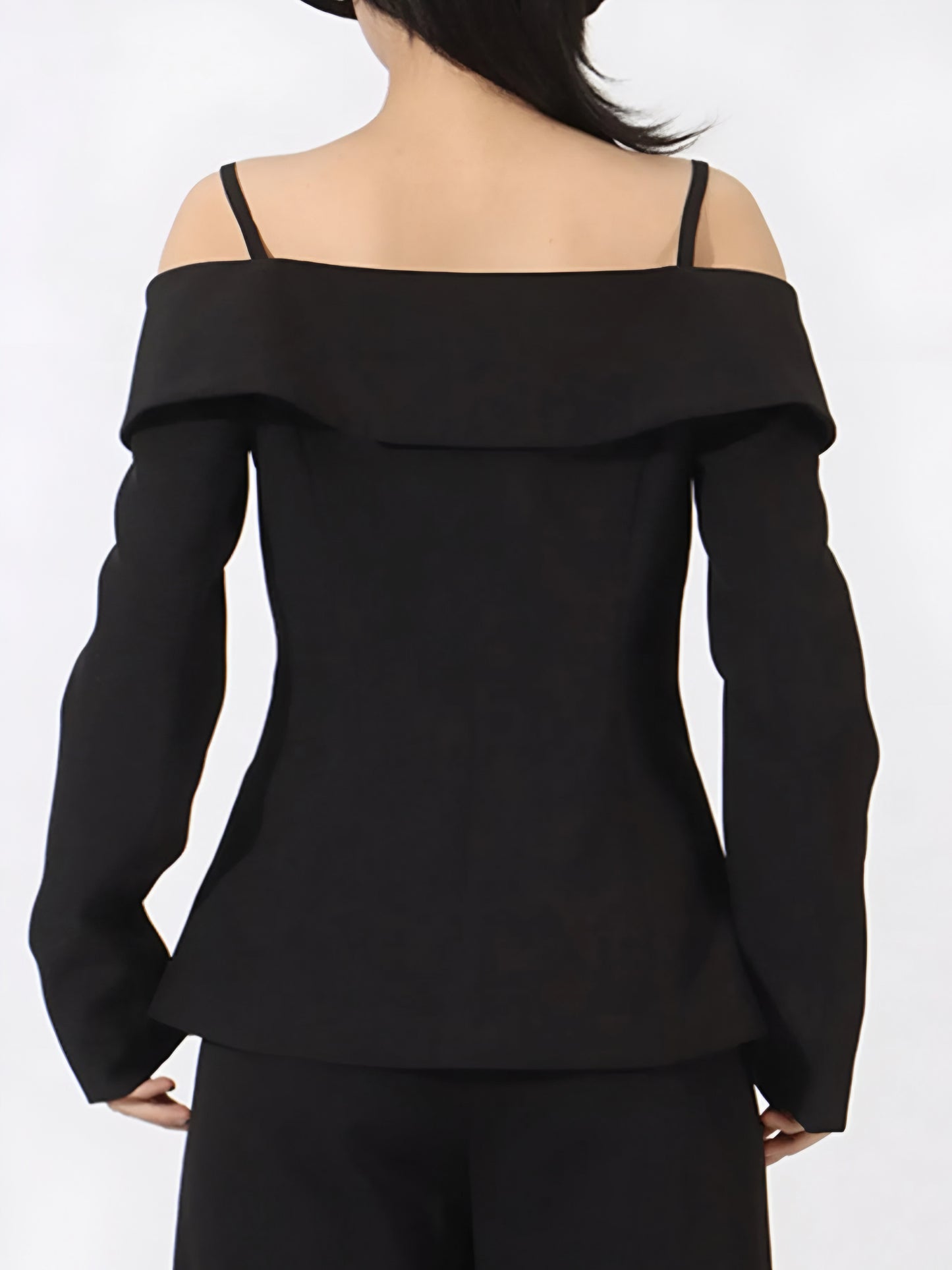 back view of black off-shoulder high fashion style blazer worn by a woman on a white background